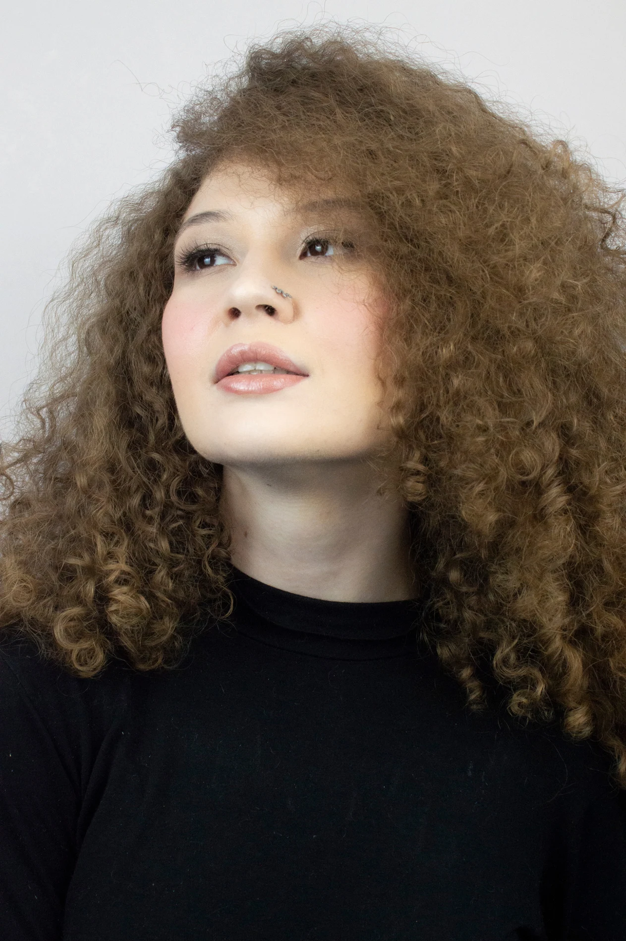 Portrait with voluminous curls and a black top.