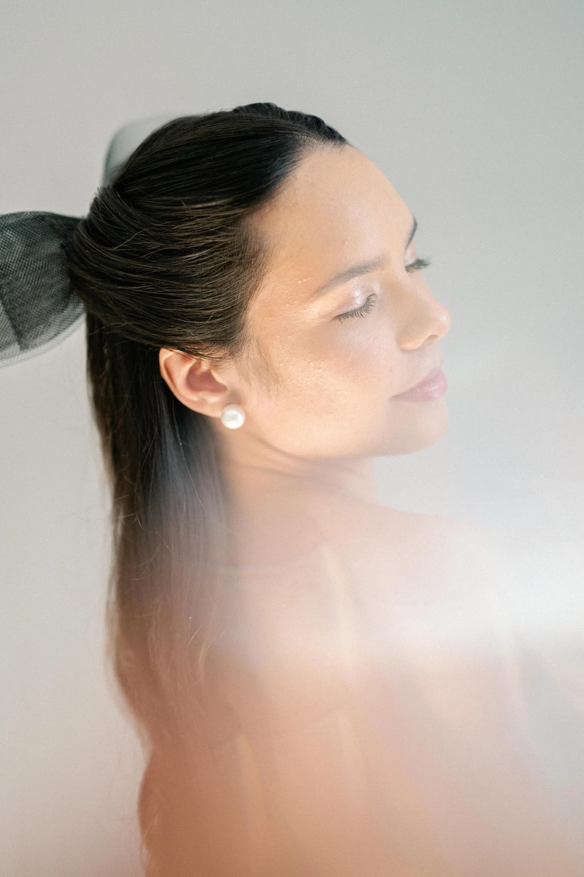 Close bridal portrait with luminous skin and swept-back hair.